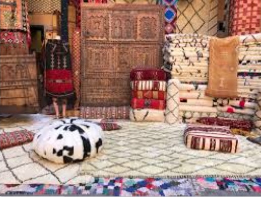 Handmade Moroccan rugs, Beni Ourain carpets and leather poufs in a rug shop on a rug shopping tour in Marrakech